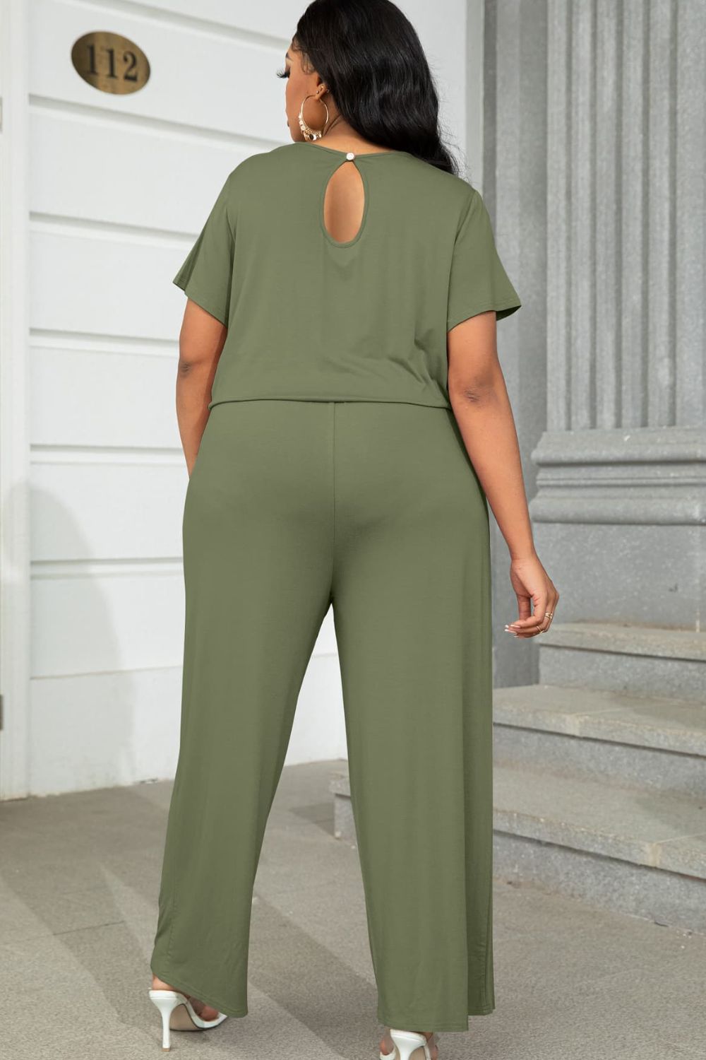 Plus size BELLA drawstring waist short sleeve jumpsuit with a relaxed fit, displayed on a hanger.