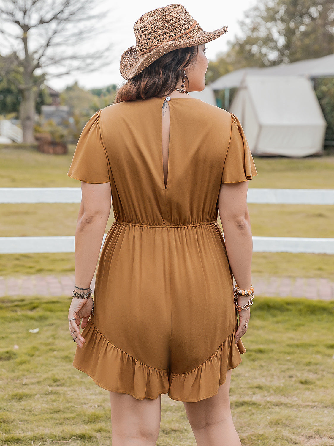Plus size BELLA ruffled V-neck short sleeve romper with a flowy fit and floral pattern, shown on a model.