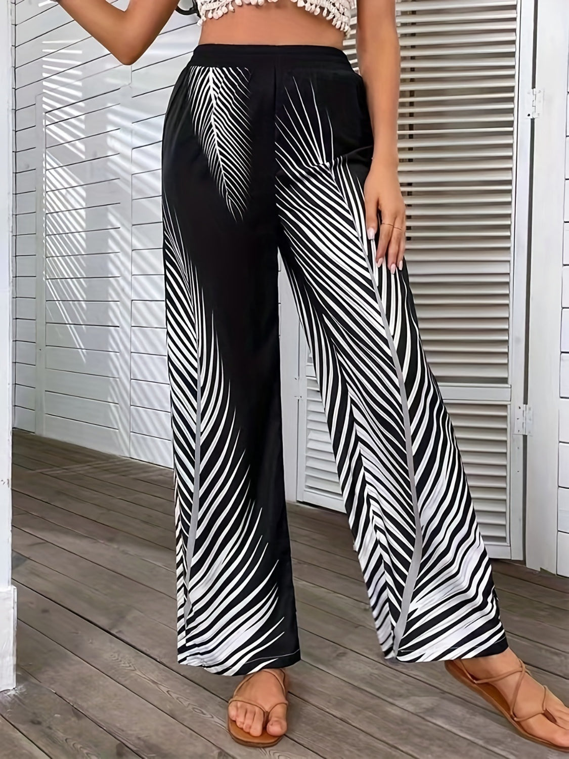 Printed wide-leg pants by BELLA from Trendsi, featuring a flowy fit and bold pattern, shown in the image.
