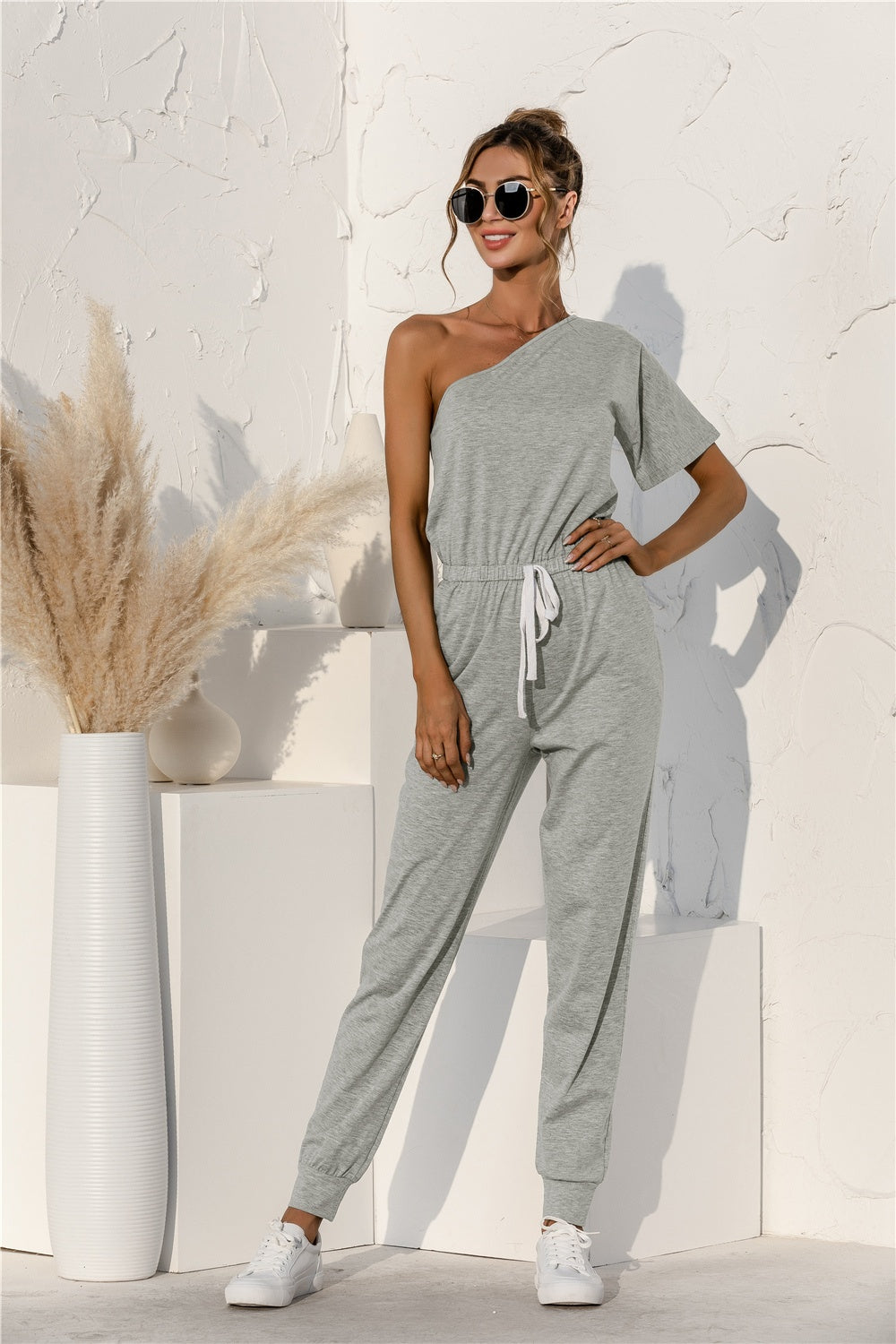 BELLA Trendsi single shoulder short sleeve jumpsuit in black, featuring a stylish one-shoulder design and relaxed fit.