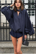 Woman wearing a navy blue top with a matching, shorts
 standing on steps.