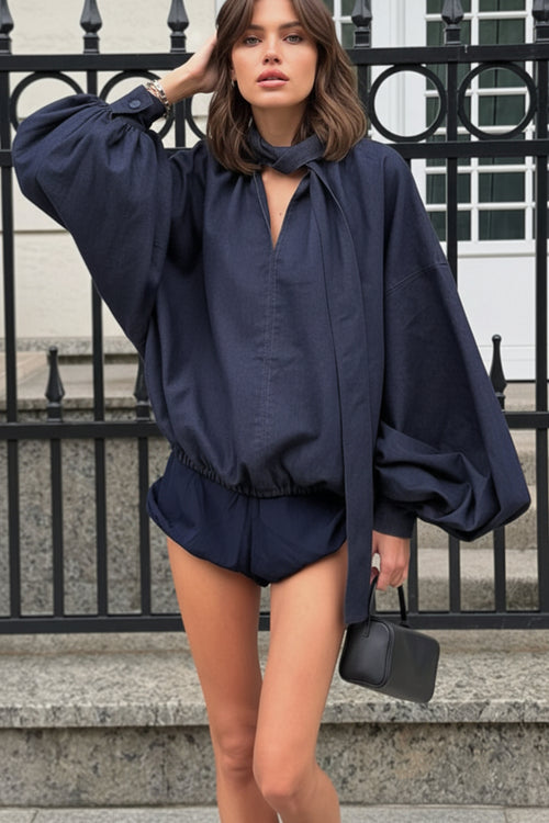 Woman wearing a navy blue top with a matching, shorts
 standing on steps.