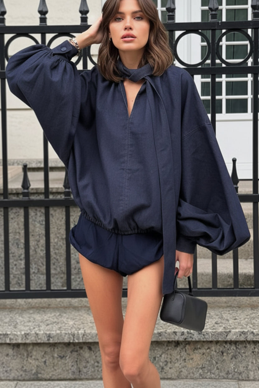 Woman wearing a navy blue top with a matching, shorts
 standing on steps.