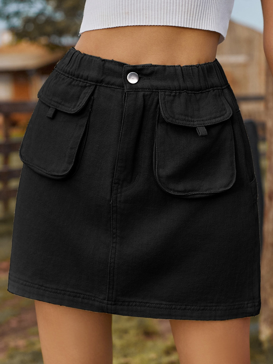 BELLA pocketed elastic waist denim skirt from Trendsi, showing front view with pockets, fitted waist, and classic denim texture.