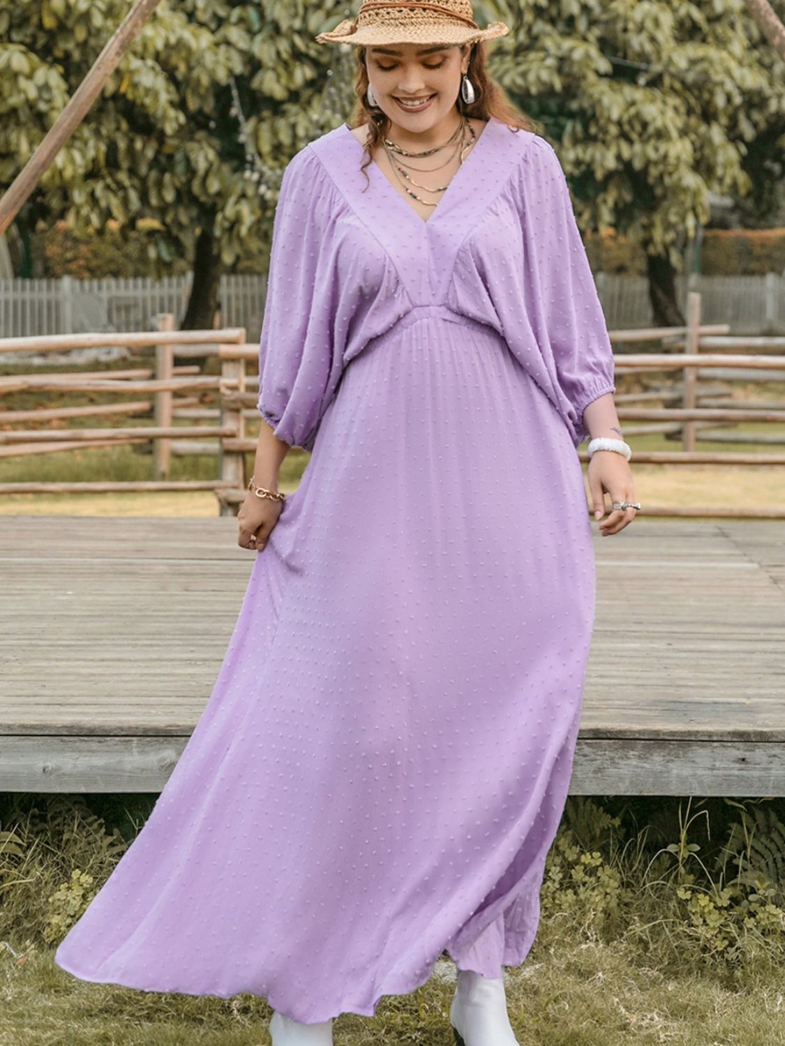 Plus size Swiss dot V-neck midi dress by BELLA, featuring a flowy fabric and stylish V-neckline, displayed on a hanger.