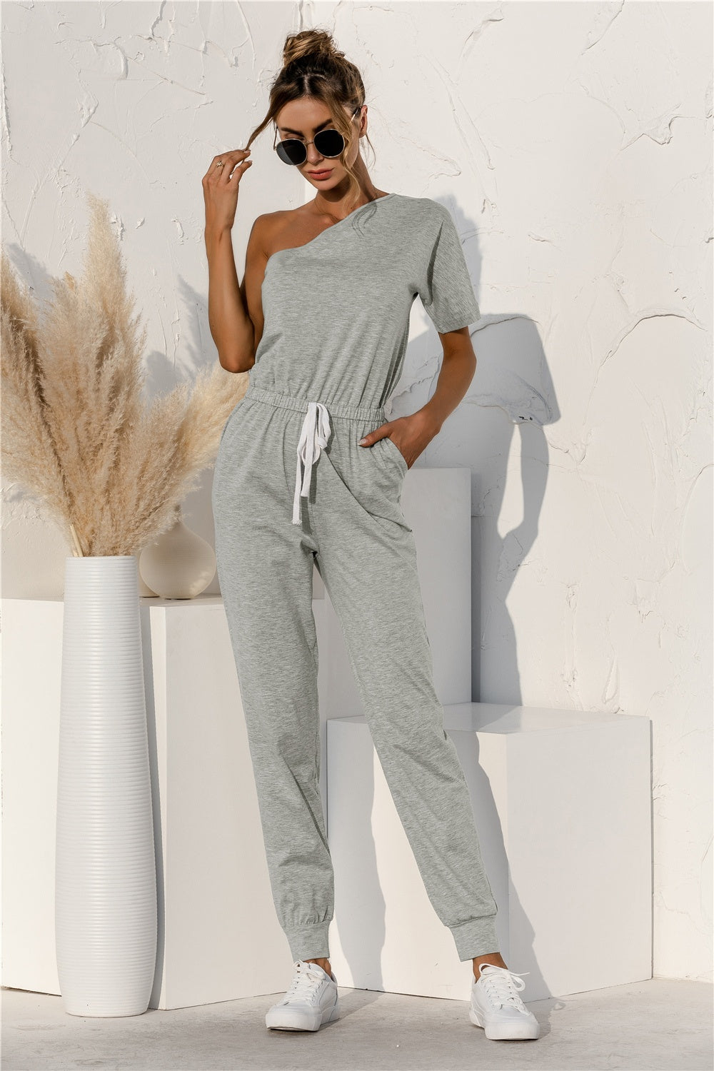 BELLA trendsi single shoulder short sleeve jumpsuit displayed on a hanger, featuring a fitted silhouette and stylish design.