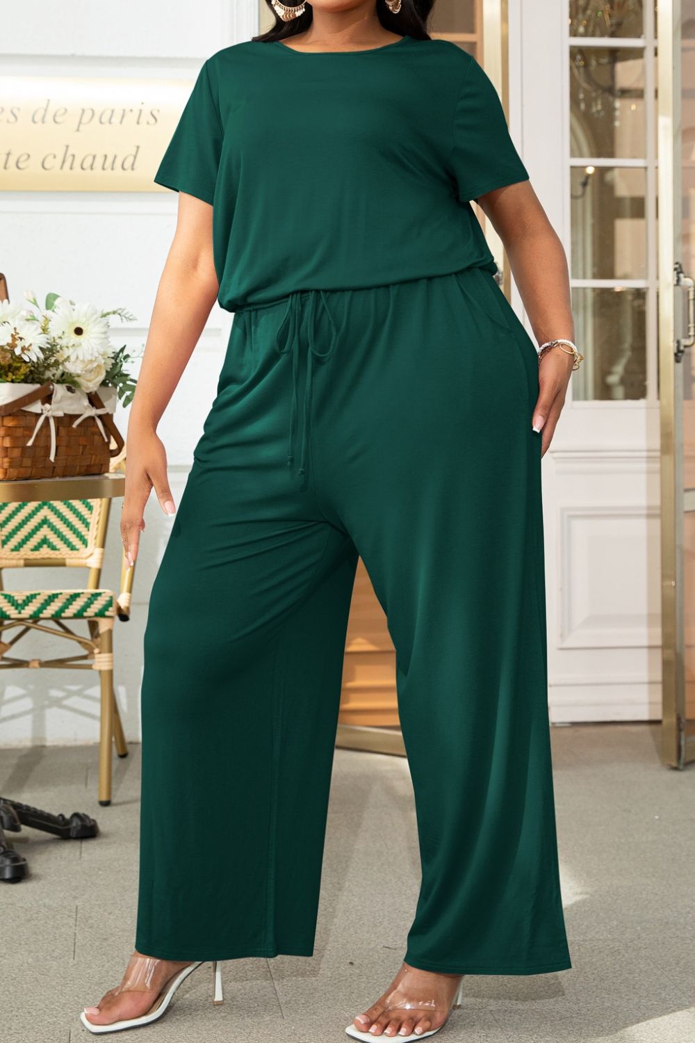Plus size BELLA jumpsuit with drawstring waist and short sleeves, casual trendy outfit, shown in a relaxed fit.