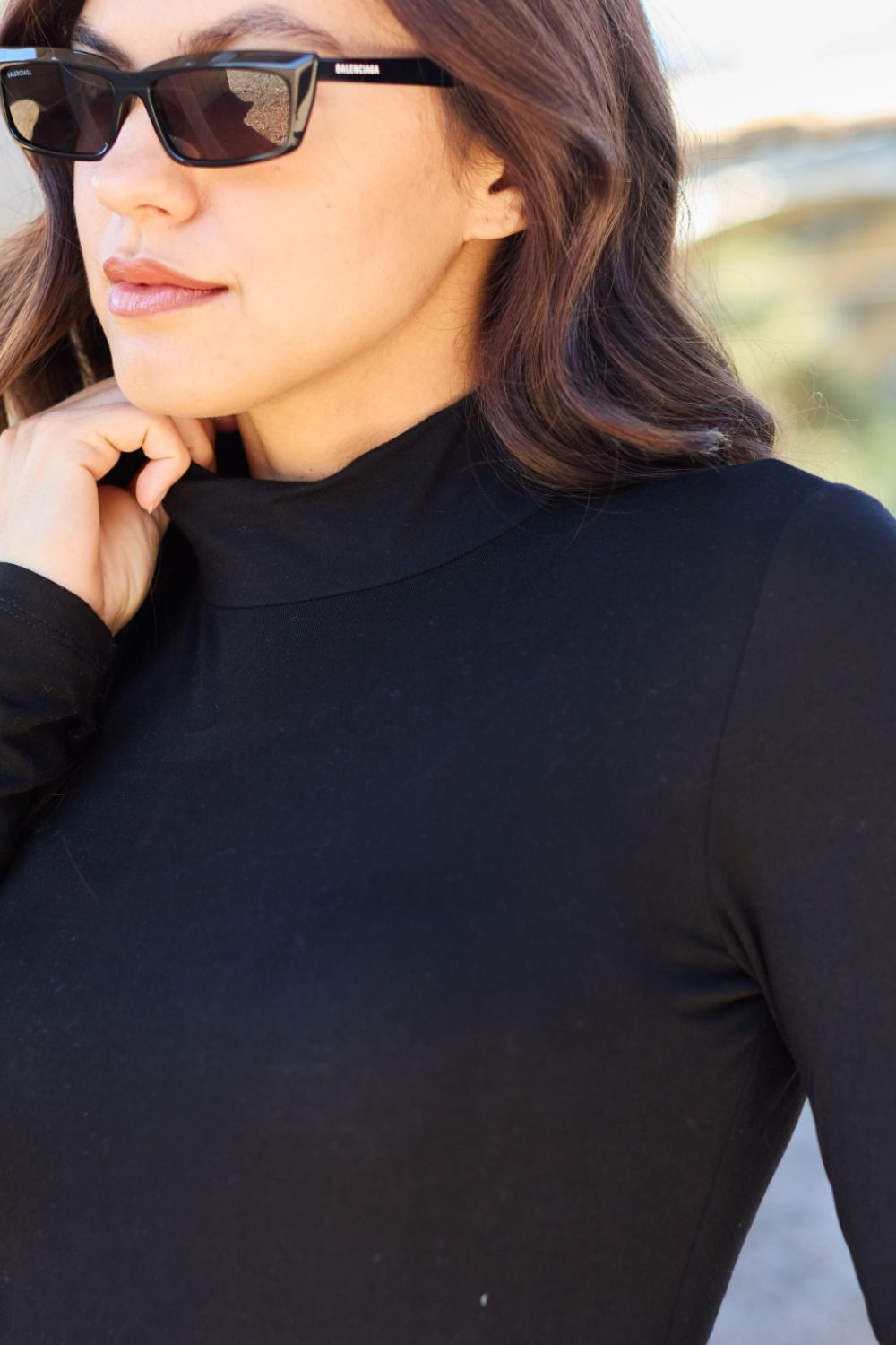 BELLA trendsi full size black mock neck long sleeve bodysuit displayed on a model, showcasing its fitted style and sleek design.