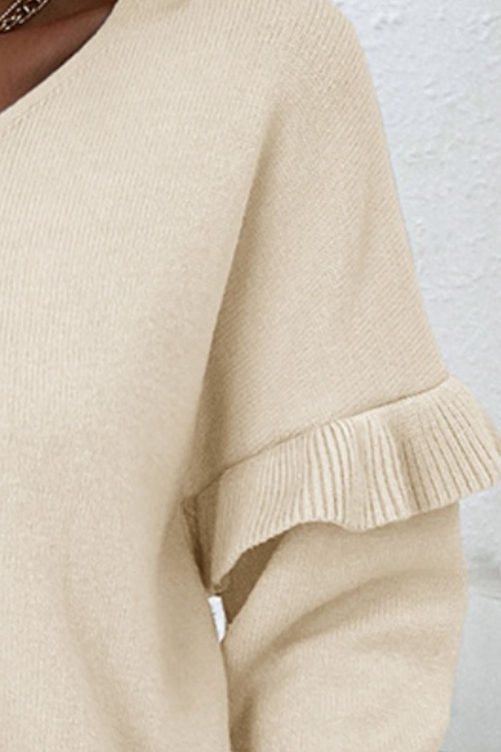 BELLA V-neck ruffle trim long sleeve sweater in soft knit fabric, featuring a stylish V-neck and feminine ruffle details.
