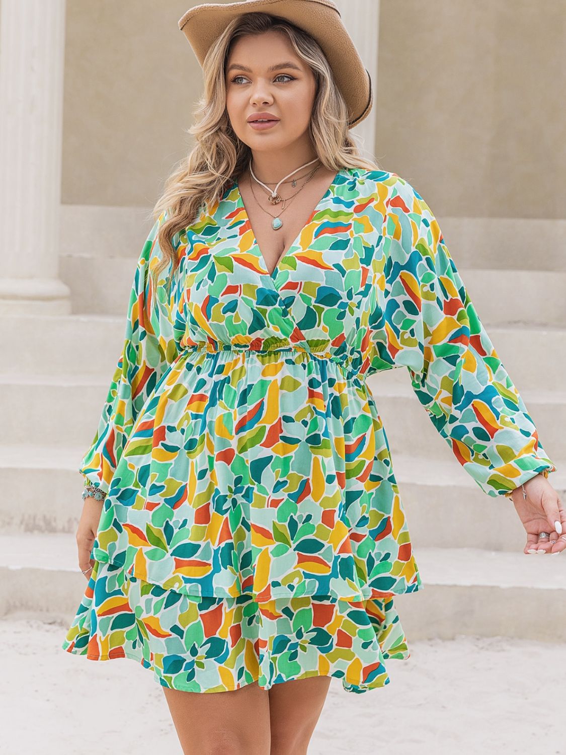 Plus size printed surplice long sleeve mini dress by BELLA, featuring a flattering wrap design and vibrant print.