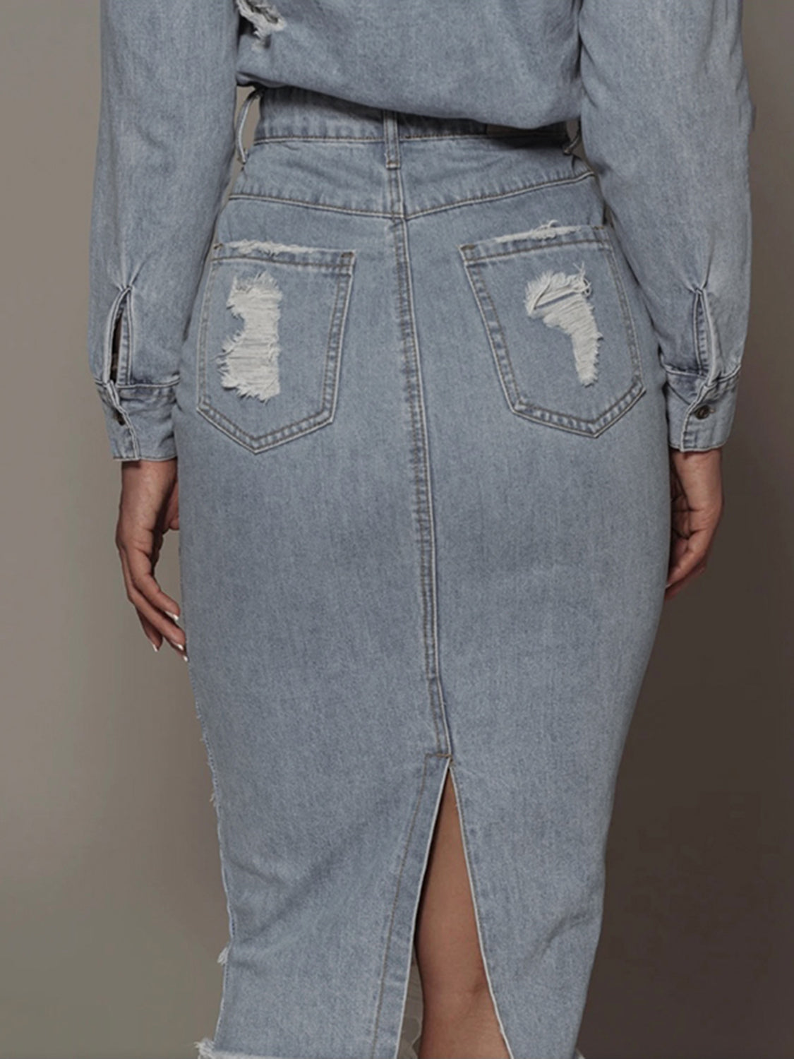 BELLA distressed slit denim skirt from Trendsi featuring a high-waisted fit and edgy ripped design, shown on a model.