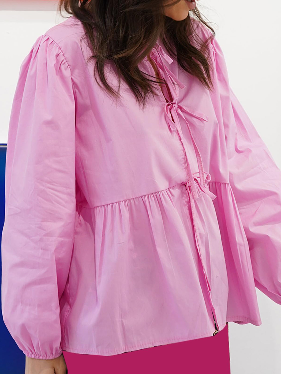 BELLA BLA tied round neck long sleeve blouse featuring a trendy design, displayed on a hanger with a neutral background.