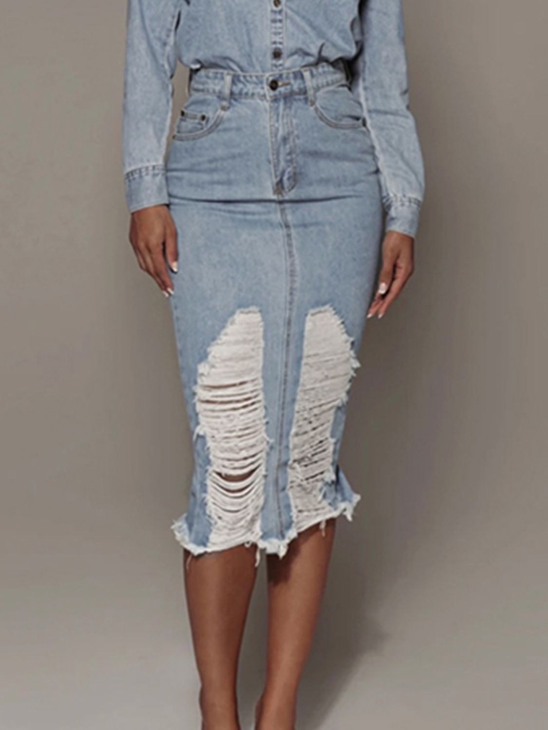 BELLA distressed slit denim skirt from Trendsi, featuring a high waist, frayed hem, and distressed details, styled for a casual look.