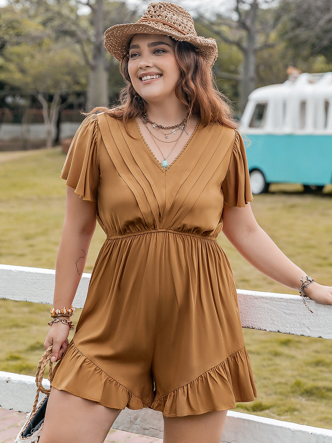 Plus size BELLA ruffled V-neck short sleeve romper with flowing fabric and floral pattern, styled for a trendy look.