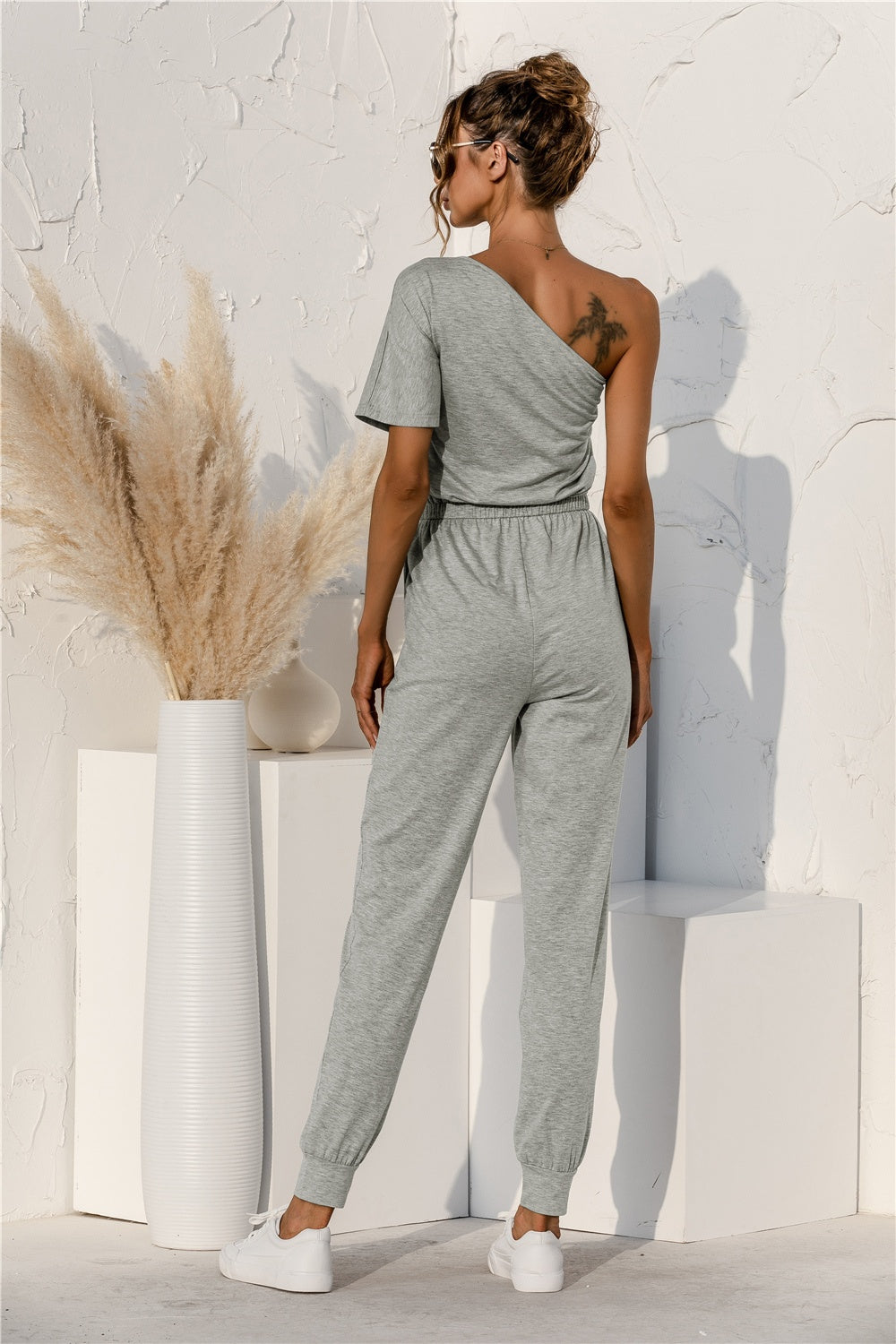 BELLA Trendsi single shoulder short sleeve jumpsuit featuring a trendy design and stylish fit, shown on a model.